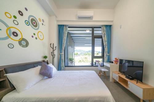 a bedroom with a bed and a tv and a window at 橙香民宿 in Dongshan