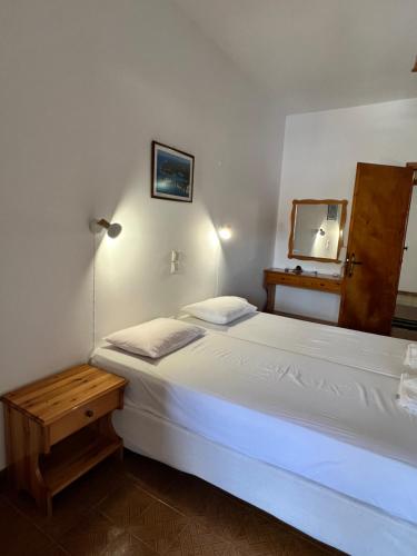 a bedroom with a white bed and a mirror at ERIDA Accommodation in Lákka