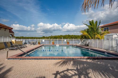 a swimming pool in a yard with a fence at Captain's Table Hotel by Everglades Adventures in Everglades City