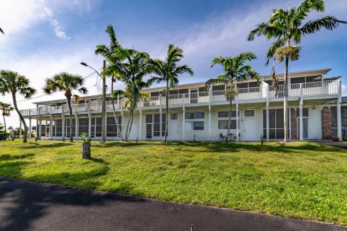 a large white building with palm trees in front of it at Captain's Table Hotel by Everglades Adventures in Everglades City