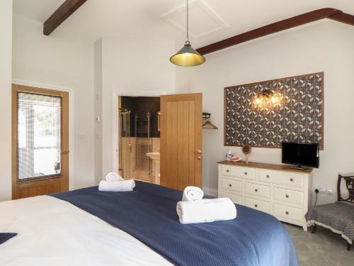 a bedroom with a large bed with two towels on it at The Forge in Falmouth