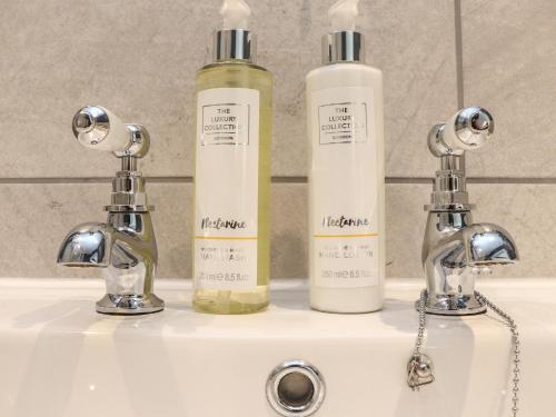 a bathroom sink with two bottles on top of it at The Forge in Falmouth