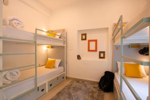 a bedroom with two bunk beds with yellow pillows at Zostel Rishikesh, Laxman Jhula in Rishīkesh