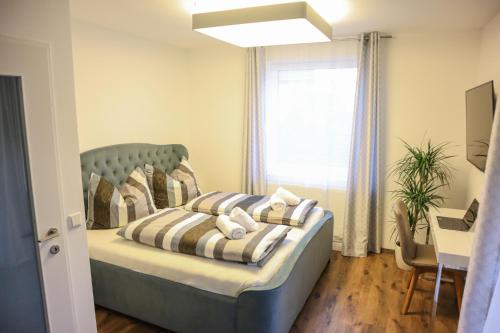 a bedroom with a bed and a desk and a window at Living8-Appartements in Bad Ischl