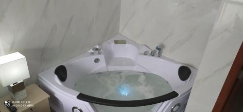 a white bath tub in a bathroom with a sink at Ecusuites Riverfront One Vista al Río Jacuzzi Hidro in Guayaquil