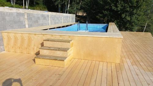 a wooden deck with a swimming pool and stairs at Cortina resort in Ivanjica