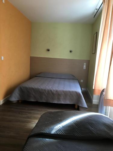 Ένα ή περισσότερα κρεβάτια σε δωμάτιο στο Hôtel Au Val De Saône Free Parking