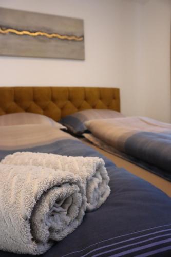 a bed with a white towel on top of it at Living8-Appartements in Bad Ischl
