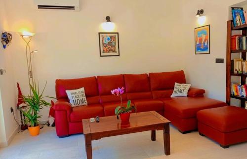 uma sala de estar com um sofá vermelho e uma mesa de centro em Casa Alice em Ližnjan