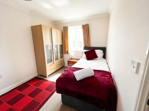 una camera con un letto e un tappeto rosso di 4 Bedroom house for Contractors,family,free parking,study,internet in ipswich a Ipswich