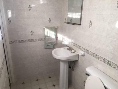a bathroom with a sink and a toilet and a mirror at Departamento Rivadavia in Guaymallen