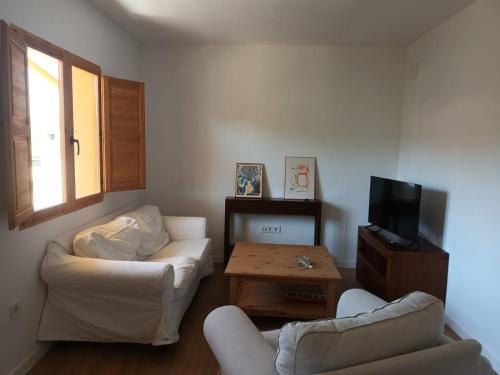 uma sala de estar com dois sofás e uma televisão em Un hogar en el Pinar em Navaleno
