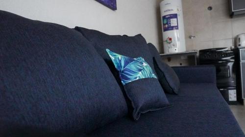 Un sofá azul con una almohada con un pez. en Departamento Soberania totalmente amoblado en 