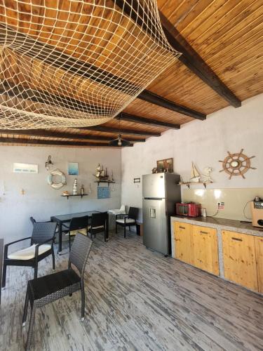 eine Küche mit einem Tisch und Stühlen sowie einem Kühlschrank in der Unterkunft Vila Kalypso in Schitul