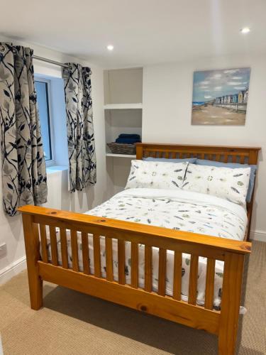 een slaapkamer met een houten bed voor een raam bij Harbour Apartment in Barmouth