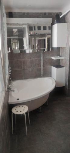 un bagno con vasca e sgabello. di logement chambre seul sur ou dortoir mixte a Roquemaure