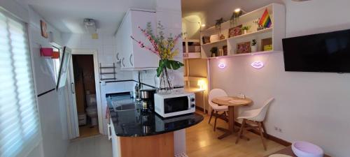 uma sala de estar com uma mesa e um micro-ondas em Mini Loft en Calle Amparo em Madrid