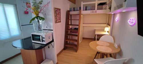 um pequeno quarto com uma mesa e um micro-ondas em Mini Loft en Calle Amparo em Madri