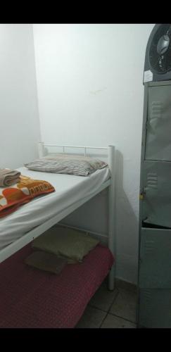 - une chambre avec des lits superposés et une commode dans l'établissement Pousada Garcia, à São Paulo