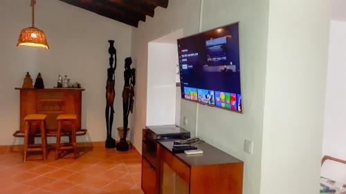 a living room with a flat screen tv on a wall at Vila Saraz in Campinho