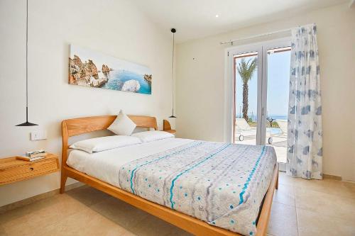 1 dormitorio con 1 cama y vistas al océano en VILLA DEL BORGO con piscina e jacuzzi, en Scopello