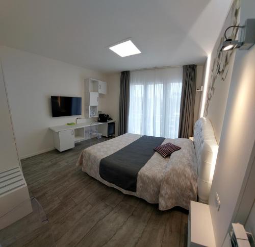una camera d'albergo con letto e TV di La Brise a Marina di Pietrasanta