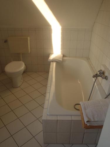 a white bathroom with a tub and a toilet at Triton II in Hohwacht