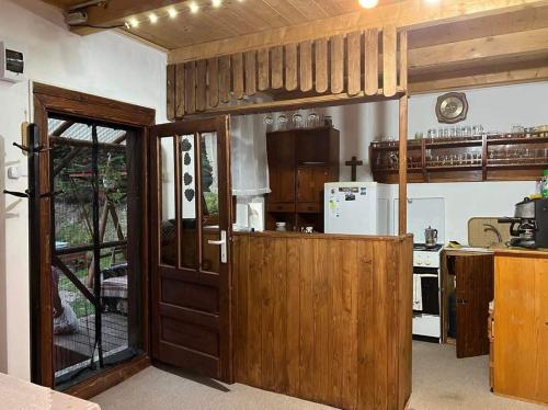 uma cozinha com uma grande porta de madeira e um fogão em Csillag kulcsoshaz em Gheorgheni