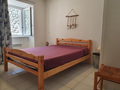 梅拉的住宿－Gites Boullé，一间卧室设有一张木床和一个窗户。