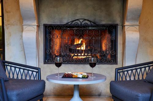 a table in front of a fireplace with two glasses of wine at Kenwood Inn & Spa in Kenwood