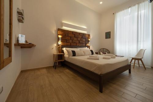 a bedroom with a large bed with a wooden headboard at Adventor Eco-Suites in Rome