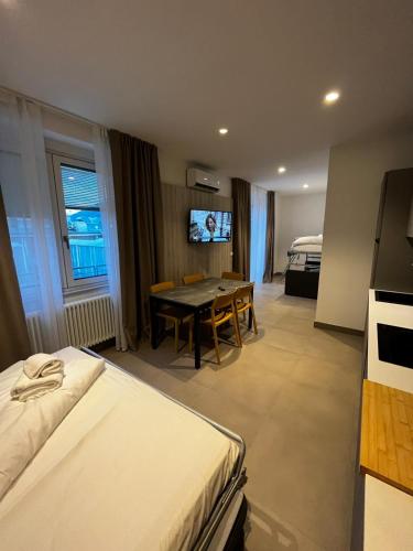 a hotel room with a bed and a table and a tv at Bilo - Apartments for rent in Trento