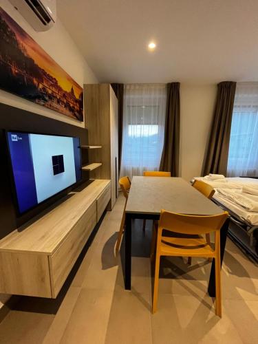 a room with a table and a tv and a bed at Bilo - Apartments for rent in Trento