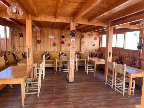 a dining room with wooden tables and chairs at Dar Surf in Taghazout