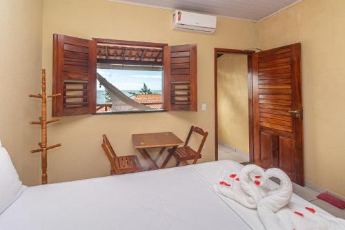 a bedroom with a bed and a table and a window at Hotel Preá in Prea