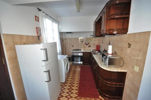 een keuken met een witte koelkast en een fornuis bij Casa da Salga in Angra do Heroísmo