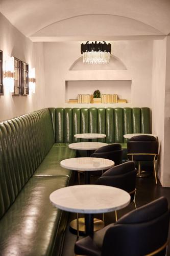 a green couch in a restaurant with tables and chairs at Kenwood Inn & Spa in Kenwood