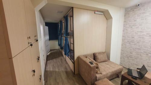 a living room with a couch and a door to a hallway at Bonvenon capsule Hostel in Yerevan