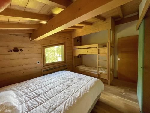 une chambre avec un lit dans une cabane en bois dans l'établissement Appartement 3 Pièces avec Cheminée et Wifi à Megève, Près des Pistes - FR-1-453-293, à Megève