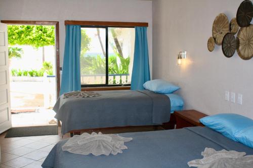 a hotel room with two beds and a window at Holiday Hotel in San Pedro