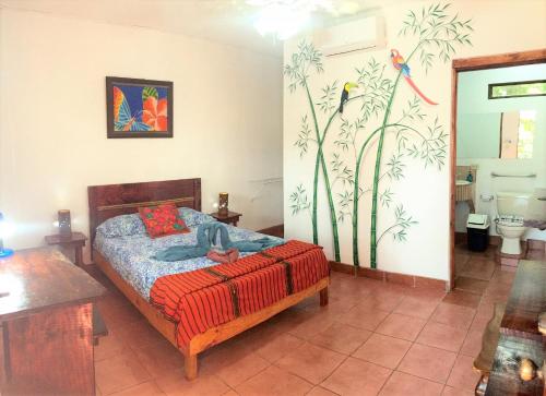 a bedroom with a bed and a bathroom at Hotel Tropical Sands Dominical in Dominical