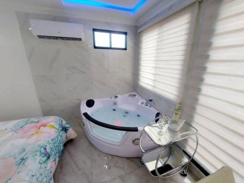 a bathroom with a bath tub and a bed in it at Ecuabook Via a la Costa Gye Puerto Azul in Guayaquil