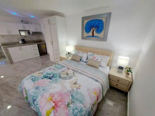 a bedroom with a large bed with flowers on it at Ecuabook Via a la Costa Gye Puerto Azul in Guayaquil