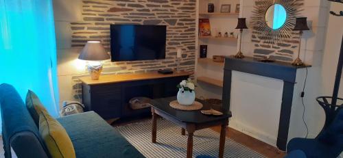 un salon avec un canapé bleu et une télévision dans l'établissement Le GENISTA, à Angers