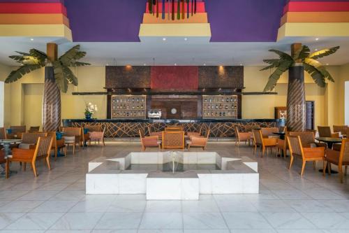 a restaurant with a fountain in the middle of a lobby at Iberostar Bahia - All Inclusive in Praia do Forte