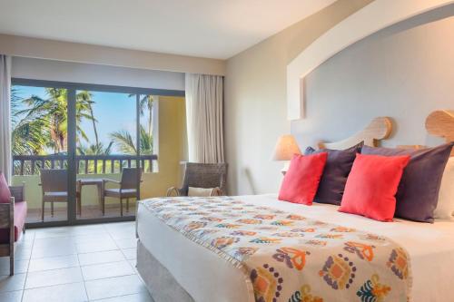 a bedroom with a bed with a view of the ocean at Iberostar Waves Bahia - All Inclusive in Praia do Forte