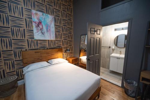 a bedroom with a white bed and a bathroom at The Flat NYC in New York