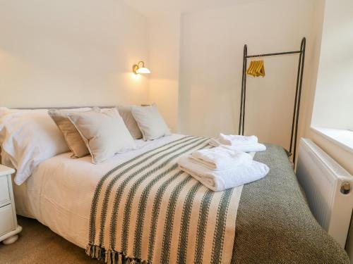 a bedroom with a bed with towels on it at Halfpenny Cottage in Lechlade