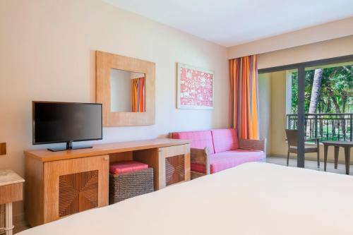 a room with a bed, television and a desk at Iberostar Bahia - All Inclusive in Praia do Forte