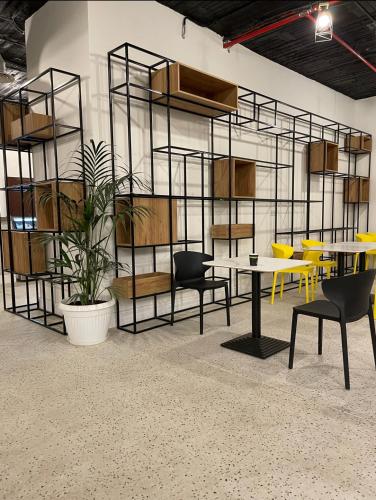a room with tables and chairs and a wall with shelves at بوابة الورود للشقق المخدومة - فئة اقتصادي in Taif